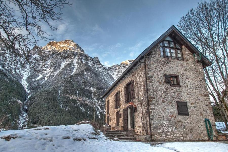 casa rural en valle de pineta entre montañas nevadas